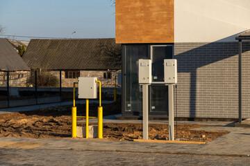 Exterior view of a newly built house with outdoor utility meters and yellow gas pipes installed