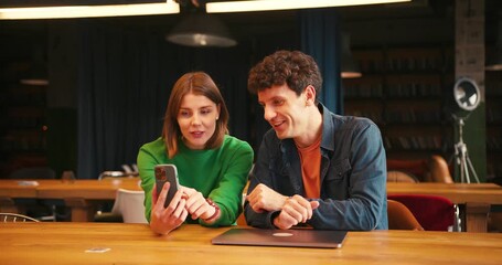 Colleagues discussing project ideas using smartphone and laptop - Powered by Adobe