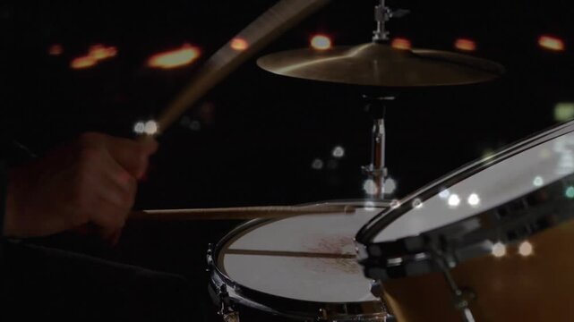 Drummer hands hovering, starting rapid alternating strokes on snare and cymbal, creating music beat