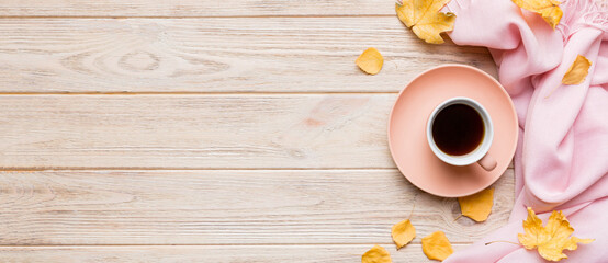 Flat lay composition with colorful Autumn cup of coffee and leaves on a color background. top view