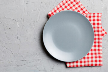 Top view on colored background empty round gray plate on tablecloth for food. Empty dish on napkin with space for your design