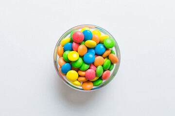 Multicolored candies in a bowl on a colored background. birthday and holiday concept. Top view with copy space