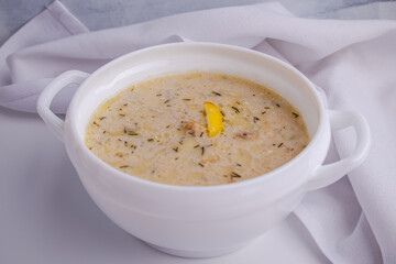 Homemade creamy fish soup with dill on a white background