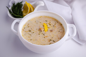 Homemade creamy fish soup with dill on a white background