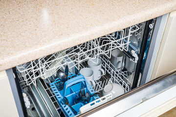 Slightly open dishwasher door from above with white plates and dishes inside