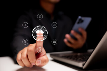 A person operates a digital device, emphasizing data backup with various icons displayed around a finger pressing the 