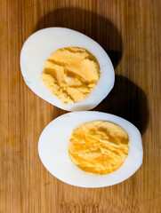 Hard-Boiled Egg Cut In Half On Wooden Board Showing Yellow Yolk Texture