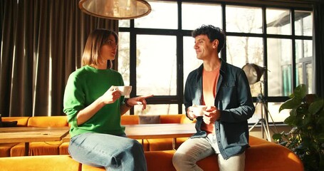 Young couple enjoying coffee and conversation in stylish cafe - Powered by Adobe