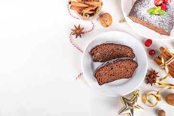 Homemade gingerbread loaf cake. Freshly baked Christmas Gingerbread chocolate cake with sugar powder topping, on white festive decorated background