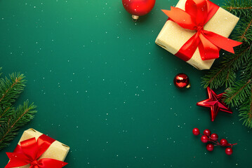 Merry Christmas and Happy Holidays greeting card, frame, border. New Year. Red Christmas ornaments and gifts, presents on green background top view. Xmas holiday festive theme. Christmas decoration