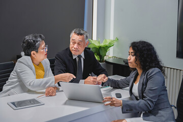 Diverse business team analyzing financial data and performance metrics during a corporate meeting. Professional teamwork, strategy planning, and data-driven decision making in modern office.