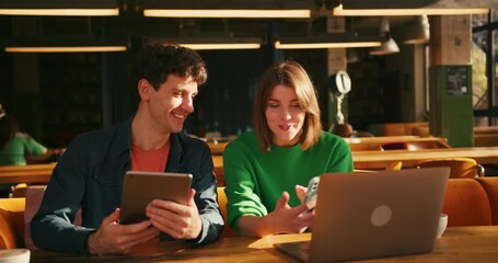 Young coworkers collaborating on project in modern cafe or in coworking - Powered by Adobe