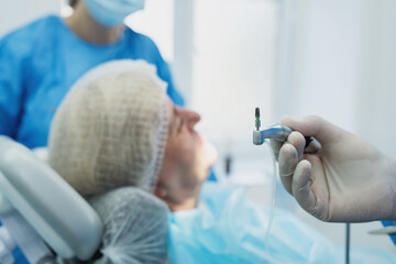 dentist surgeon installing an implant to an elderly woman. Prosthetic dentistry, false teeth