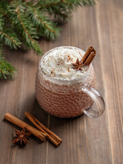 Hot chocolate with whipped cream in a cup on a dark wooden background