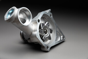 High-quality spare parts for your car. Car maintenance. New water pump for the engine cooling system on a gray gradient background.