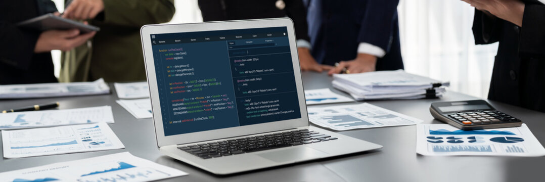 Panorama shot analyst team utilizing BI Fintech to analyze financial report with laptop. Businesspeople analyzing BI data dashboard displayed on laptop screen for business insight. Prodigy