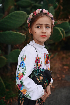 Young girl in floral dress with thoughtful expression