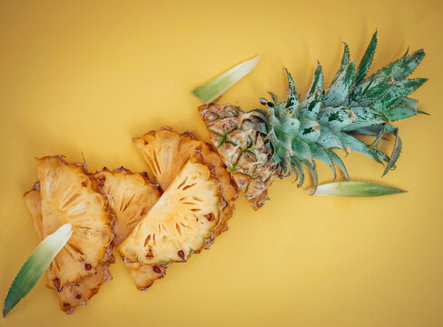 Pineapple slices on a vibrant yellow backdrop