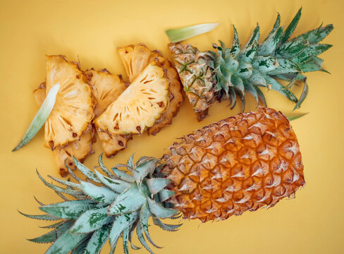 Fresh pineapple slices on vibrant yellow background