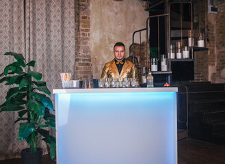 Bartender in gold jacket starts preparing cocktails