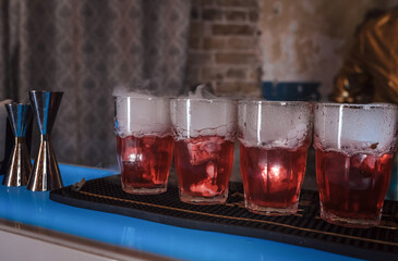 Vibrant red cocktails with a misty allure on the bar