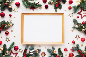 Fototapeta premium Christmas card with fir branches, wooden frame and red decoration top view. White festive background for winter and New Year holidays.