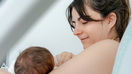 Newborn baby and mother bonding in hospital room