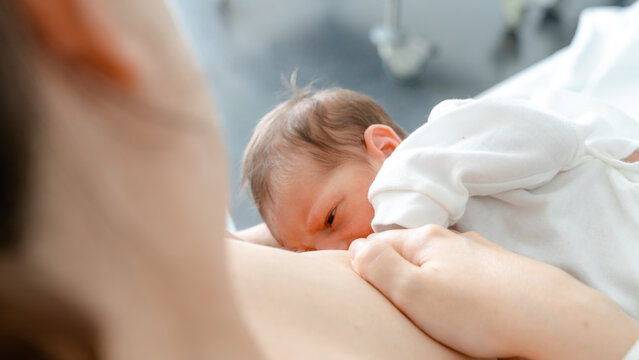 Mother breastfeeding newborn in a comforting embrace