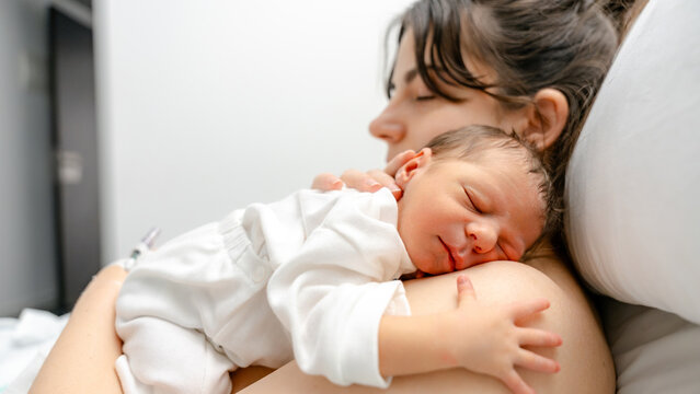 Newborn snuggling on mother in hospital setting