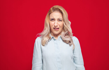 Dissatisfied young woman has disgusting expression on face, isolated on white background