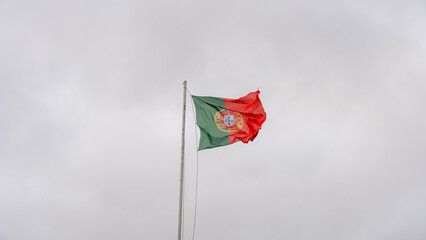 Portugal flag waving against a cloudy sky