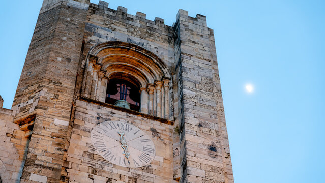 Lisbon cathedral clock and bell tower against a clear sky