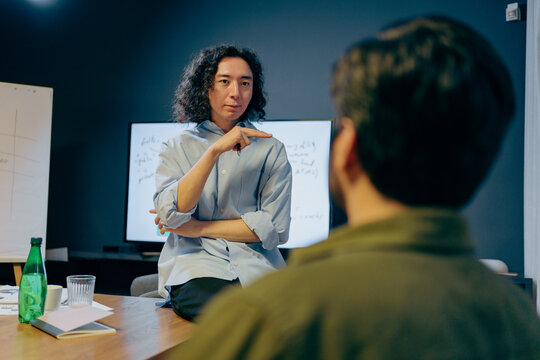 passionate asian user experience researcher explores structural concepts over informal gathering with snacks