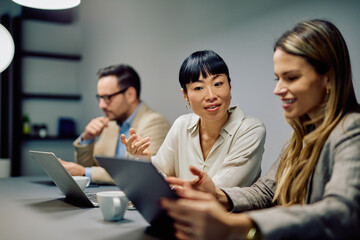 Diverse business team collaborating while discussing project strategy in a modern office environment. Professional adults working together