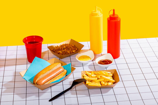 Hot dog meal with fries on a vibrant yellow backdrop