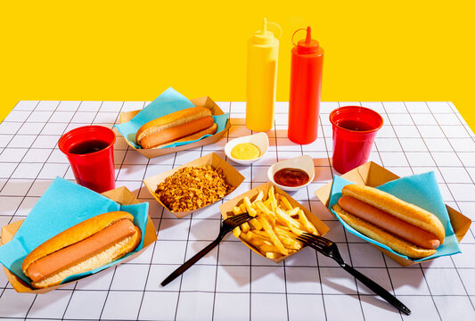 Delicious hot dog meal with condiments on yellow background