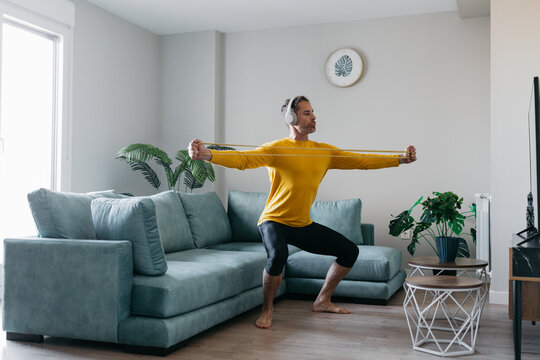Man exercising with resistance band in living room