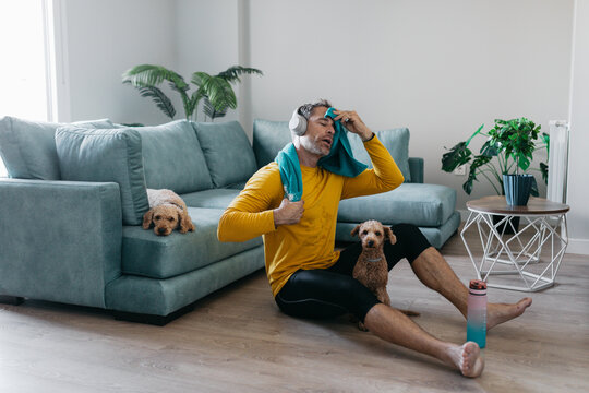 Man exercising at home with dogs on a relaxing day