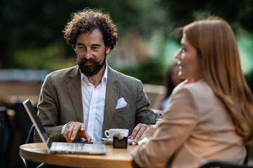Business people working on laptop at outdoor cafe