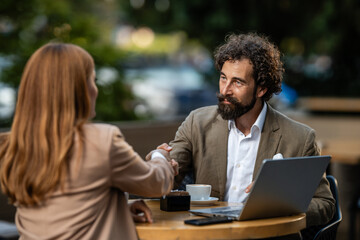 Business people shaking hands at outdoor cafe meeting