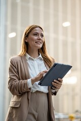 Fototapeta premium Businesswoman using digital tablet and looking up with a smile