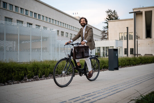 Businessman riding bicycle in urban environment
