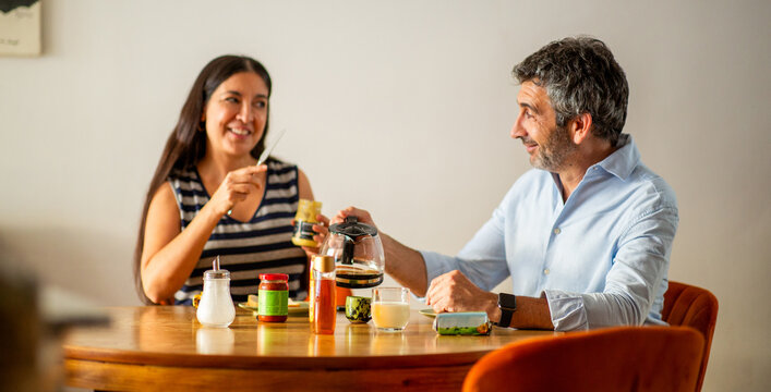 Smiling couple enjoying a relaxed breakfast and conversation