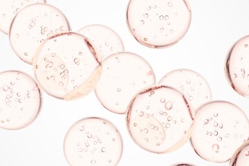 Rose-colored serum droplets with delicate air bubbles in macro view, perfect for skincare advertising, cosmetic branding, and elegant clean visual storytelling