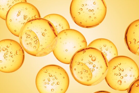 Golden liquid spheres containing suspended air bubbles, forming a smooth abstract background suitable for luxury skincare ads, wellness branding, and premium visuals