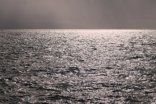 View of the wavy sea stretching out toward a calm, distant horizon