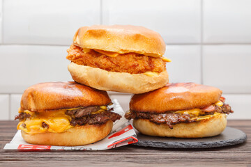 Trois smash burgers sur ardoise (smash bacon, smash chicken et double smash), gros plan. Concept fast food. 