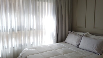 Elegant Bedroom with Cozy Bed, Light Decor, and Warm Sunlight 