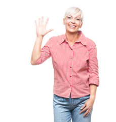 Friendly adult woman raising hand waving hello with smile face looking at camera, isolated on white background. Hi gesture.