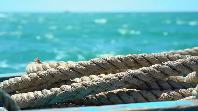 Nautical rope on boat with blurred sea backdrop, used for travel, adventure, and vacation themes